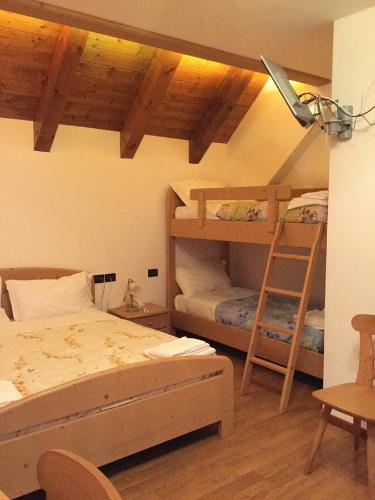 a bedroom with two bunk beds and a ladder at Albergo Al Cocul in Sùtrio