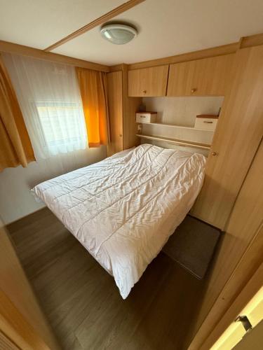 a bedroom with a bed in a small room at Camping Noetselerberg - Sallandse Stee - Stacaravan 5pers in Nijverdal