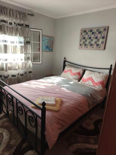 a bedroom with a bed with pink sheets and a window at Villa Sofia By The Sea in Leptokarya