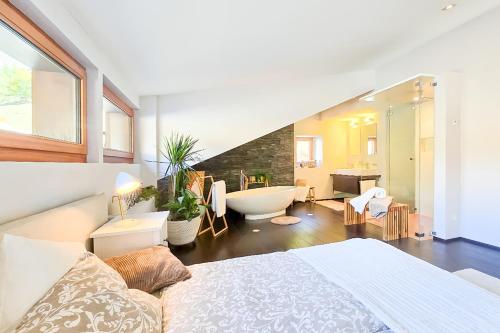 a bedroom with a bed and a bathroom with a tub at Traumhafte Ferienwohnung in den Schweizer Alpen in Saas-Grund