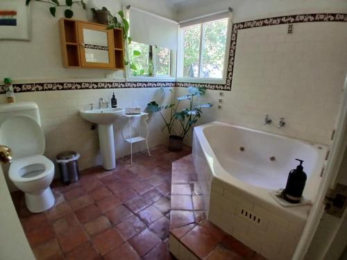 ein Badezimmer mit Badewanne, Toilette und Waschbecken in der Unterkunft Dennis Cottage Clare Valley in Auburn