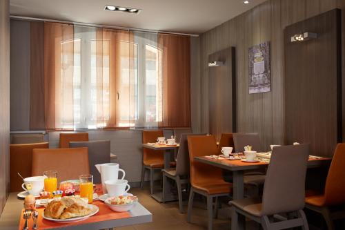 un restaurant avec des tables et des chaises avec de la nourriture dessus dans l'établissement Beaugrenelle St-Charles Tour Eiffel, à Paris