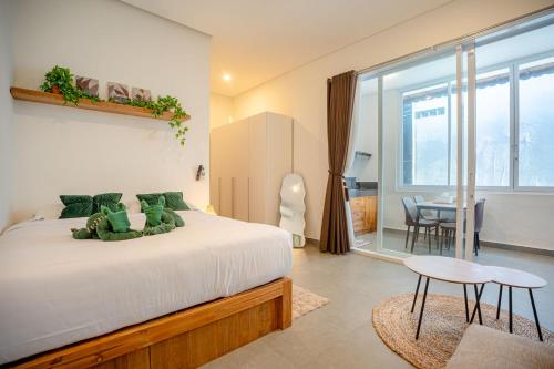a bedroom with a bed and a table and a dining room at Bali Bay By Urban Haven in Sanur