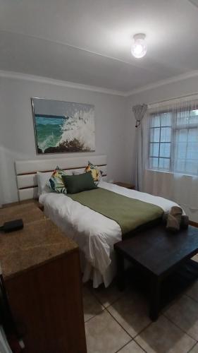 a bedroom with a large bed and a window at Maselli Lodge in Howick