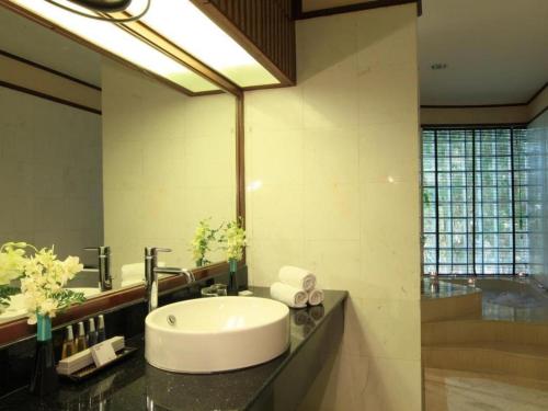 a bathroom with a sink and a large mirror at Holiday Poipet in Ban Khok (1)