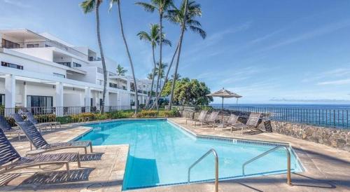 une piscine avec des chaises et l'océan en arrière-plan dans l'établissement Wyndham Royal Sea Cliff Resort, à Kailua-Kona