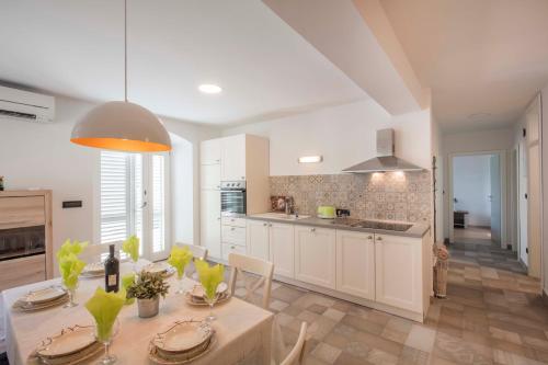 a kitchen with a table and a dining room at Apartments Villa Adrienne in Mali Lošinj