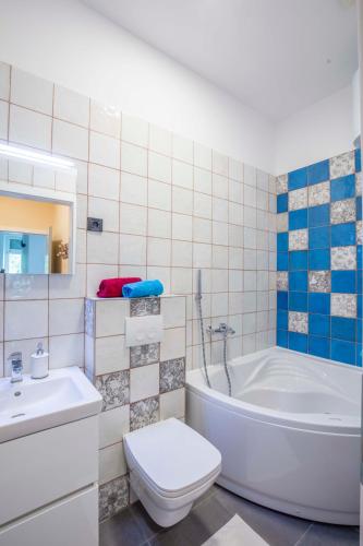 a bathroom with a tub and a toilet and a sink at Apartments Villa Adrienne in Mali Lošinj
