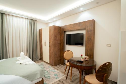a hotel room with a bed and a table and a tv at Aurora sky view suite in Sheikh Zayed