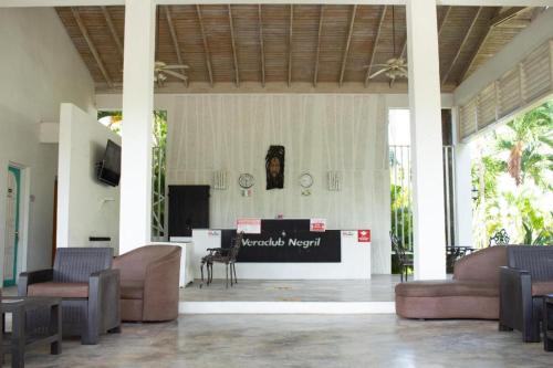 a lobby with couches and a stage in a building at Merrils Deluxe in Negril