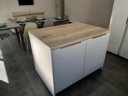 a kitchen with a white island with a wooden counter top at Gîte du champ aisé in Montaigu-Vendée