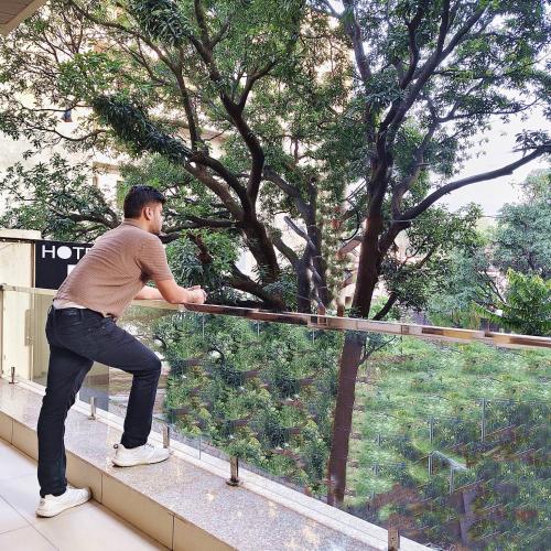 a man standing on a ledge looking at a tree at Hotel Ramayan Inn - Near Parmarth Niketan in Rishīkesh