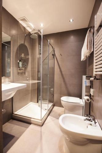 a bathroom with a shower and a toilet and a sink at Genius Hotel Downtown in Milan