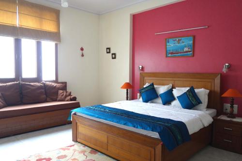 un dormitorio con una cama y un sofá en SABS Bed and Breakfast, en Nueva Delhi