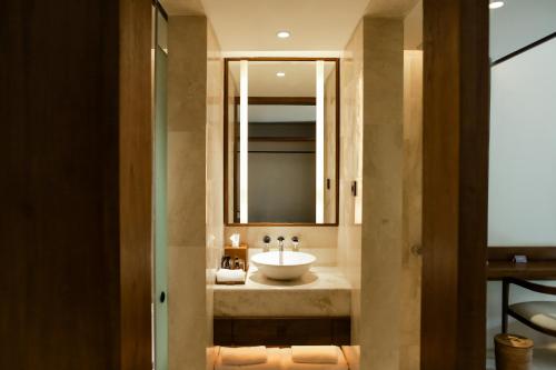 une salle de bain avec un lavabo et un miroir dans l'établissement Manohara Borobudur Cultural Center, à Borobudur