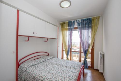 a bedroom with a bed and a large window at Vistamare in Martinsicuro