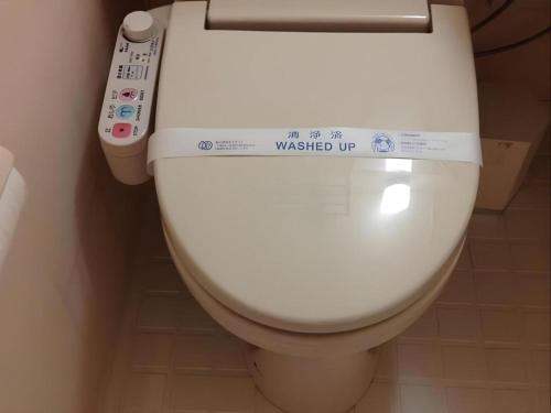 a bathroom with a toilet with a remote control at Alpha Hotel Tokushima in Nishi-shimmachi