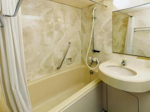 a bathroom with a sink and a toilet and a tub at Tabist Yabuki Station Hotel in Yabuki