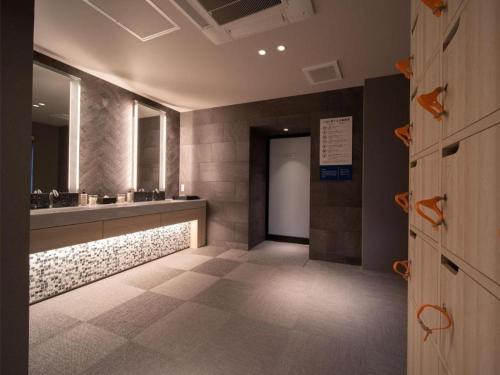 a bathroom with a sink and a mirror at Super Hotel anashiyakusyomae in Anan