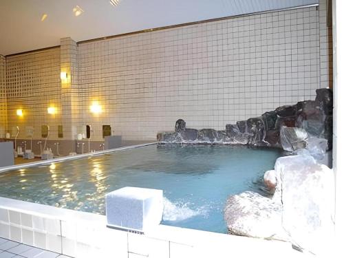 une grande piscine avec une fontaine à eau dans l'établissement Gujo Kogen Hotel, à Shōgahora