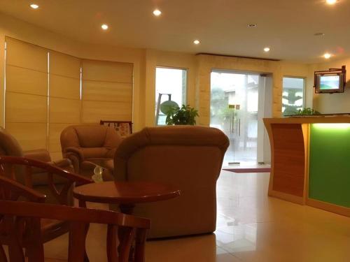 a living room with a chair and a table at King Ing Hotel in Mukah