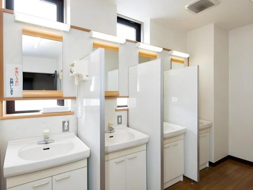 a bathroom with two sinks and two mirrors at New Biwako Hotel in Zeze-Awazumachi