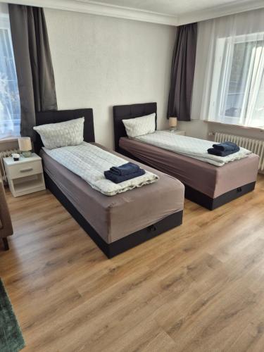 two beds in a room with wooden floors at Ferienwohnung Selb in Selb