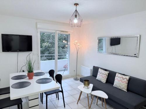 a living room with a couch and a table at T2 Pineuilh avec parking privé in Pineuilh
