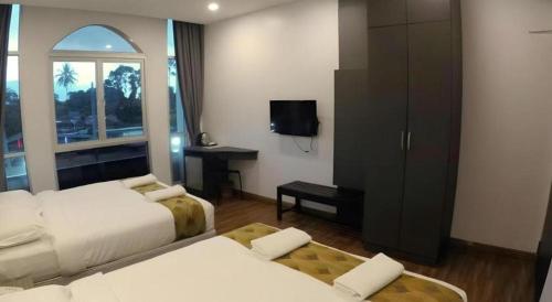 a hotel room with two beds and a television at HOTEL KAWAN BIDOR in Bidur