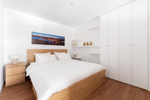a white bedroom with a large bed and white cabinets at Gaia Bella Guest House in Vila Nova de Gaia