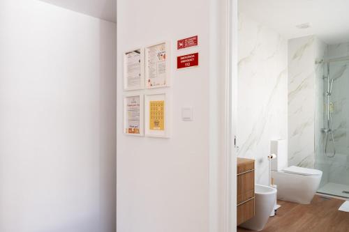 a white bathroom with a toilet and a shower at Gaia Bella Guest House in Vila Nova de Gaia