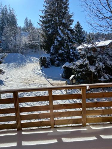 a fence covered in snow with trees in the background at Chalet authentique au calme, en lisière de forêt, montagne, sentiers 15mn Gérardmer & Alsace "Chalet Mon beau sapin" in Anould