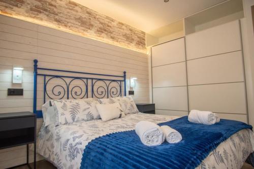a bedroom with a blue and white bed with two pillows at SERENA Apartamento Cudillero in Cudillero