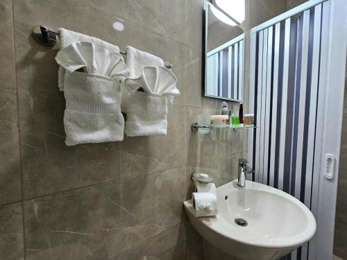 a bathroom with a white sink and a mirror at النزل الفندقي مدينة الأمير هاشم بن عبدالله الثاني للشباب in Dulaylat al Ḩamāʼidah
