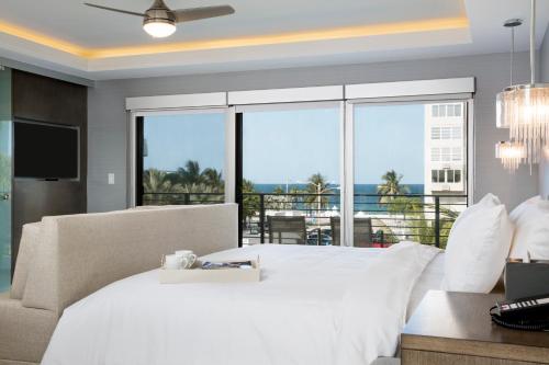 um quarto com uma cama branca e uma varanda em Elita Hotel em Fort Lauderdale