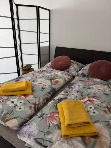 a bed with yellow blankets and pillows on it at Beautiful apartment in the city center of Poprad in Poprad