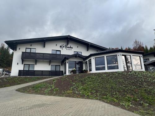 a white house with a black roof at Barka in Borsec