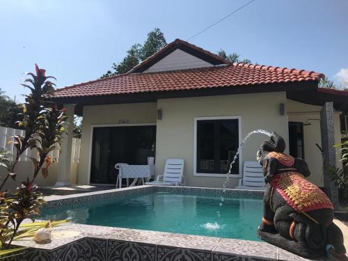 ein Haus mit einem Pool mit einer Statue davor in der Unterkunft Villa Mokara Brassia 2 bedrooms in Ko Lanta