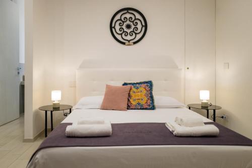 a bedroom with a large white bed with two side tables at Vivarum b&b in Bitonto