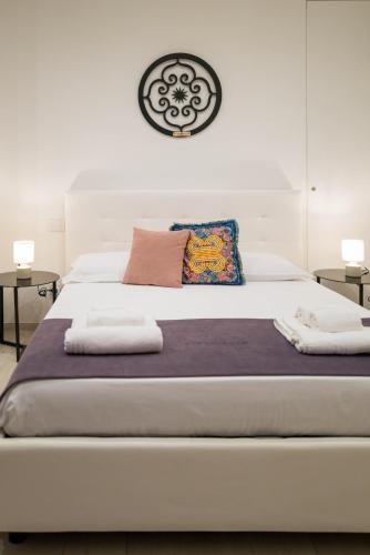 a bedroom with a large white bed and two tables at Vivarum b&b in Bitonto