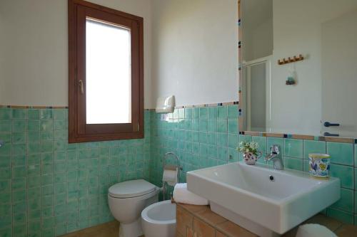 a bathroom with a sink and a toilet and a mirror at Villa Zahara in Ribera