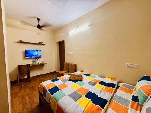 um quarto com uma cama e uma TV na parede em Citynest Residency em Pondicherry