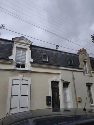 ein weißes Haus mit weißen Türen und einem Fenster in der Unterkunft Plénitude guillot in Le Mans