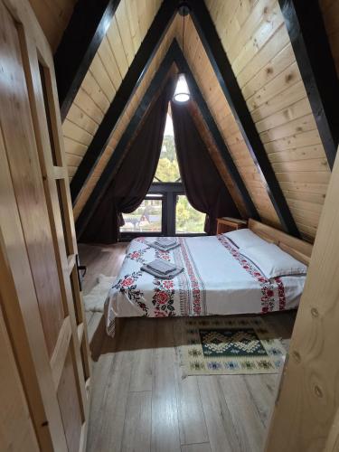 a bedroom with a bed in a attic at Cabana Sofia in Burzeşti