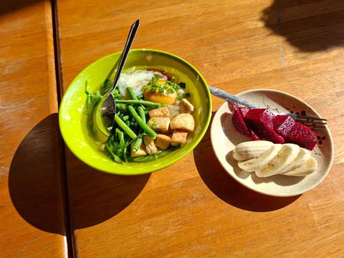 two bowls of food on a table with a plate of food at Twin House Guesthouse - Lao Experience in Luang Prabang
