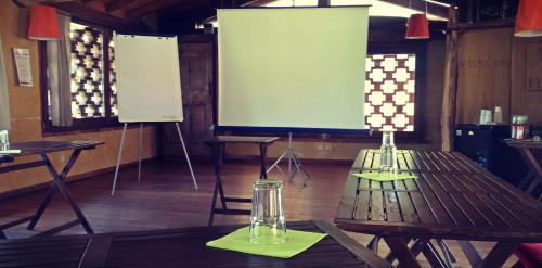 a room with two tables and a projection screen at Oasi Galbusera Bianca in Rovagnate