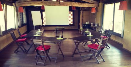 a conference room with tables and chairs and a screen at Oasi Galbusera Bianca in Rovagnate