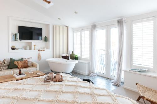 a white living room with a couch and a table at Harbour View House in St Ives