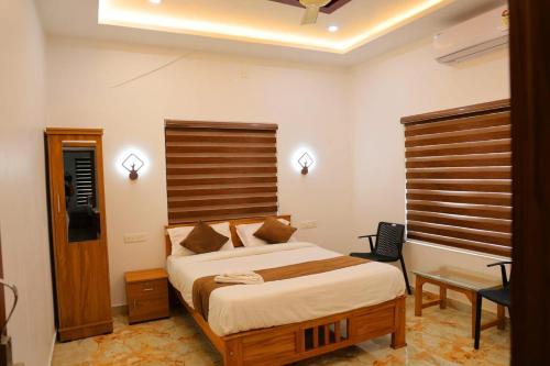 WayanadにあるJosebas Inn Vythiriの木製のヘッドボードが付いた大きなベッドのある寝室