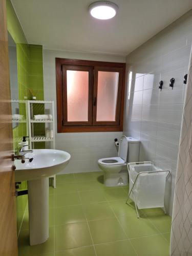a bathroom with a white sink and a toilet at Apartamento la Última Orilla - Mar y Garaje in Malpica
